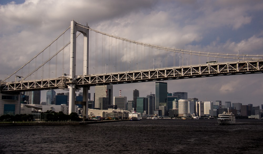 ship passing under bridge during daytime