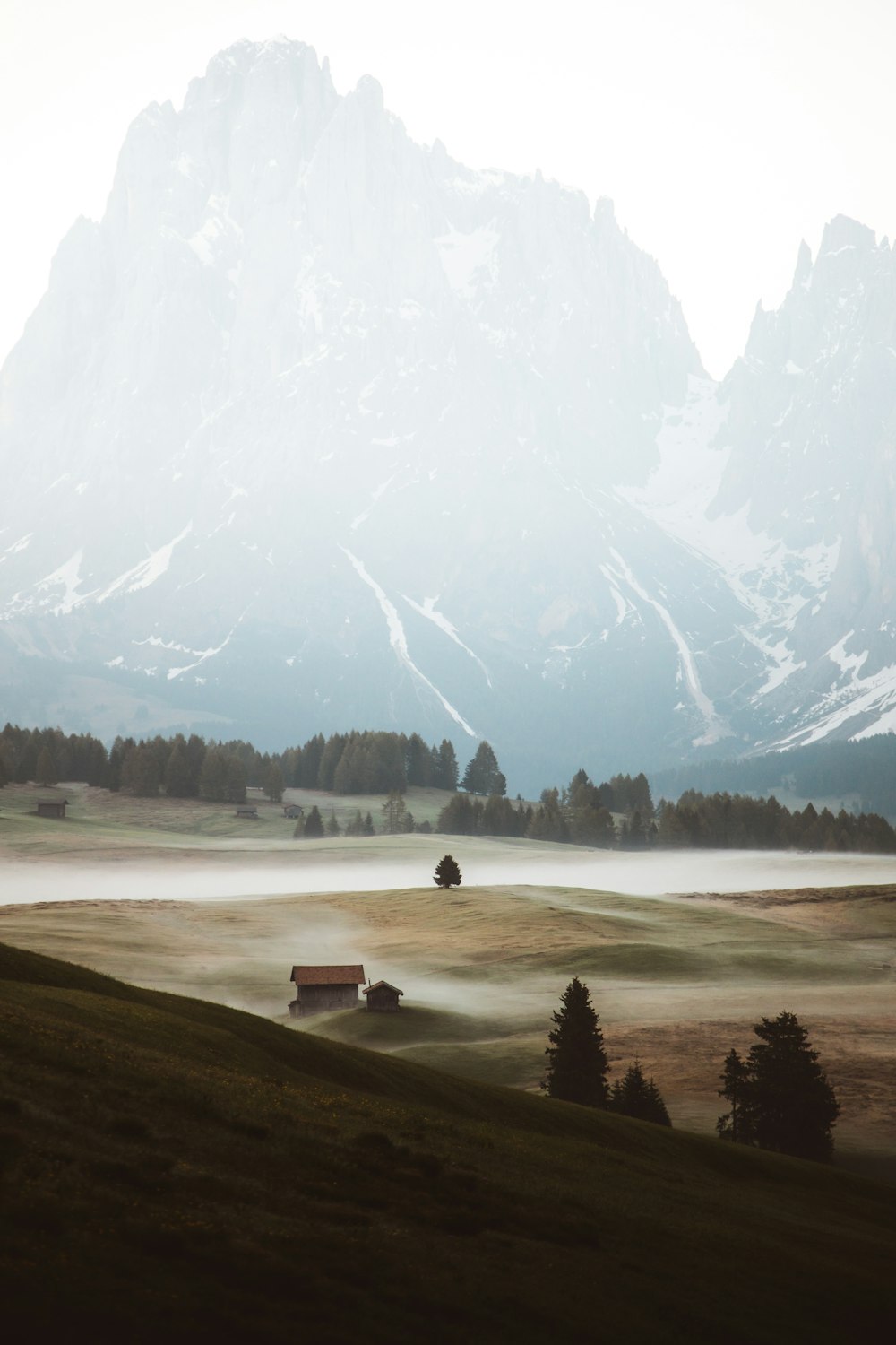 a mountain range with a house in the foreground