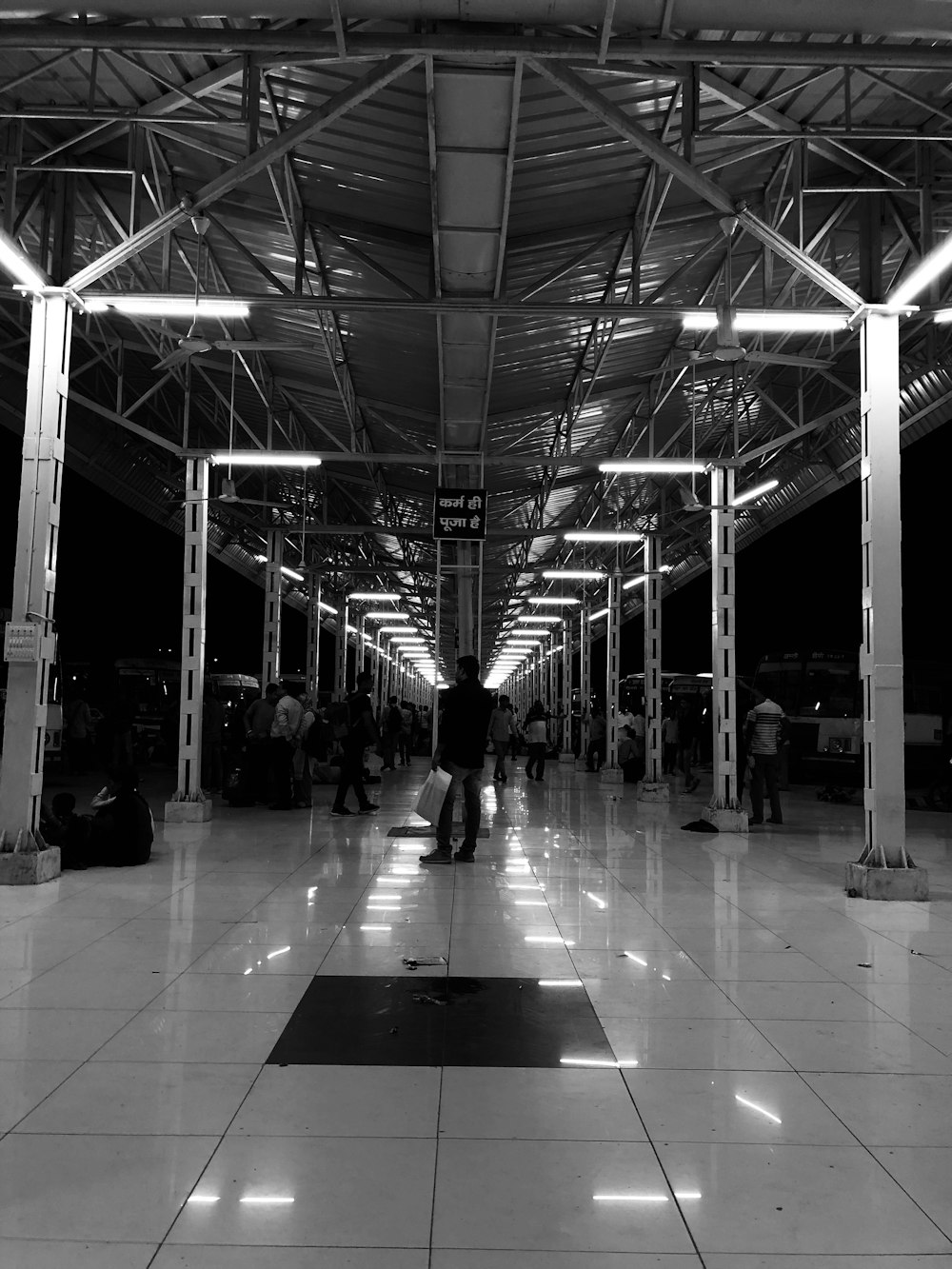 a black and white photo of people walking through an airport