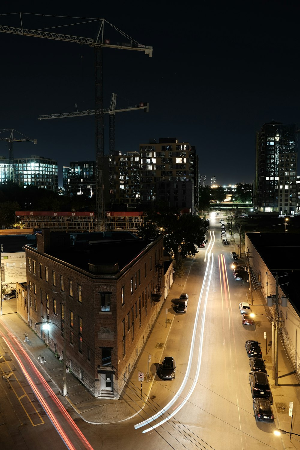 a city street at night with a construction crane in the background