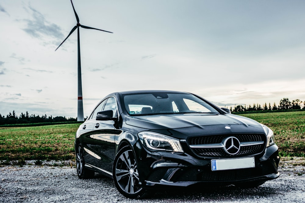 black Mercedes-Benz vehicle park near windmill