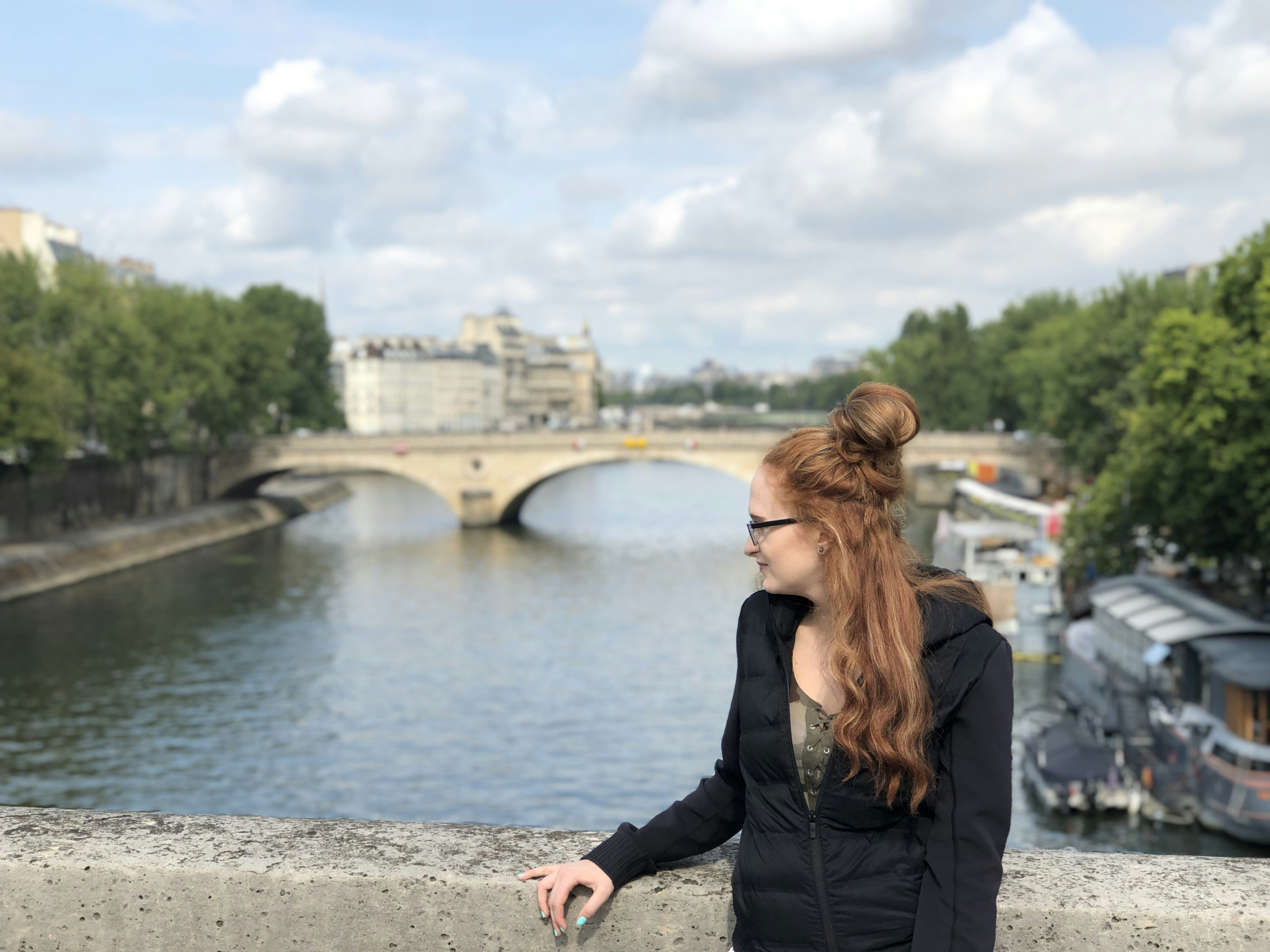 woman in black puffer jacket facing bridg