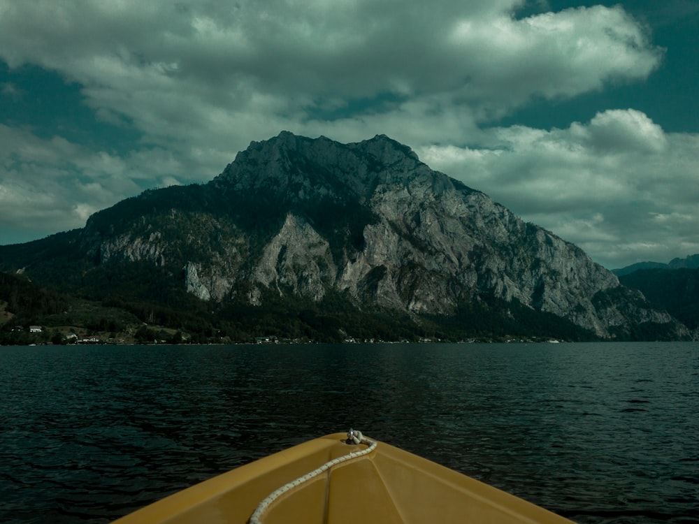 sea beside mountain under cloudy sky