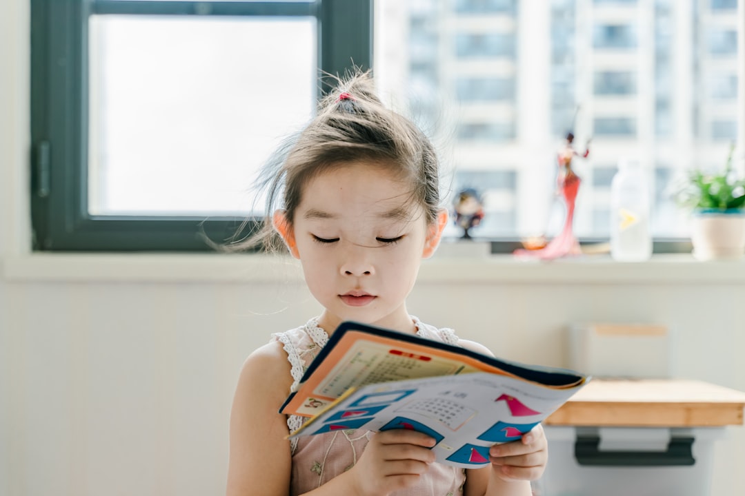 Little Asian girl, reading a book