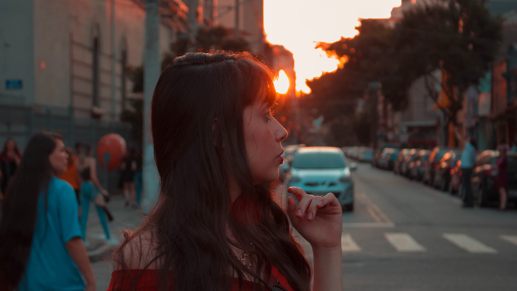 Perempuan minum di jalan kota saat matahari terbenam