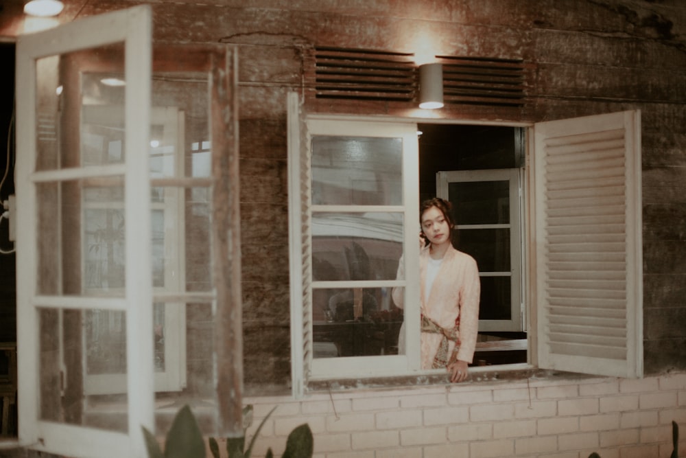 woman leaning on window frame