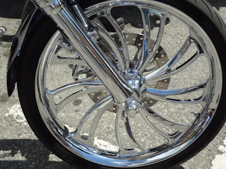 Close-up of a shiny motorcycle rim and tire ready for installation.