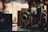 A vintage camera is prominently displayed, its intricate details and metallic components highlighted. The background is softly blurred, giving a nostalgic and classic feel to the setting.