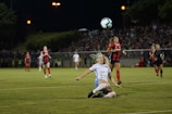 An intense soccer match with players vying for the ball under bright stadium lights.