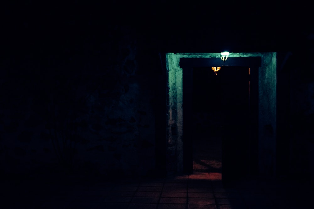 a dark hallway with a light at the end of it