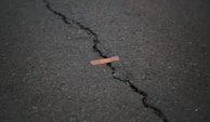 orange band aid on concrete surface crack