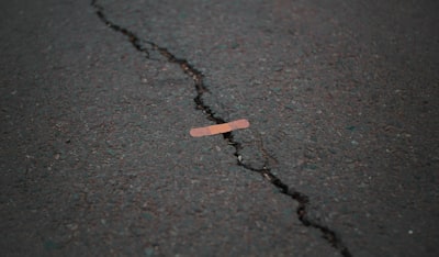 orange band aid on concrete surface crack funny zoom background