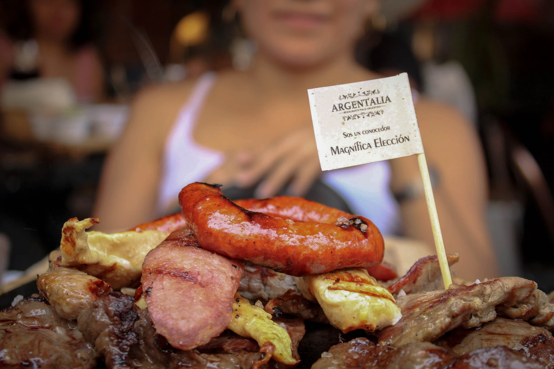 a plate of meats and sausages with a sign on it