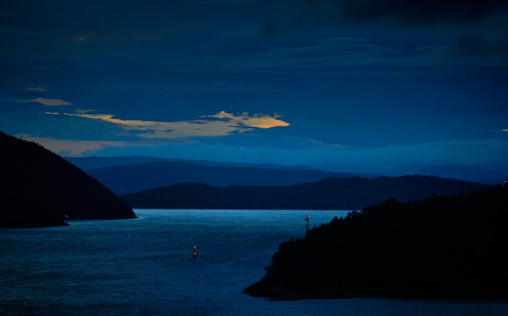 a body of water with mountains in the background