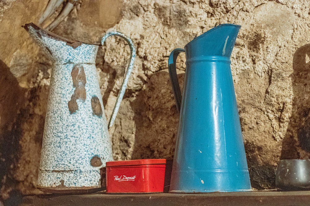 two white and blue pitchers