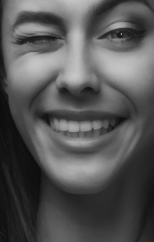 Close-up of a cam model's playful expression, inviting viewers in.