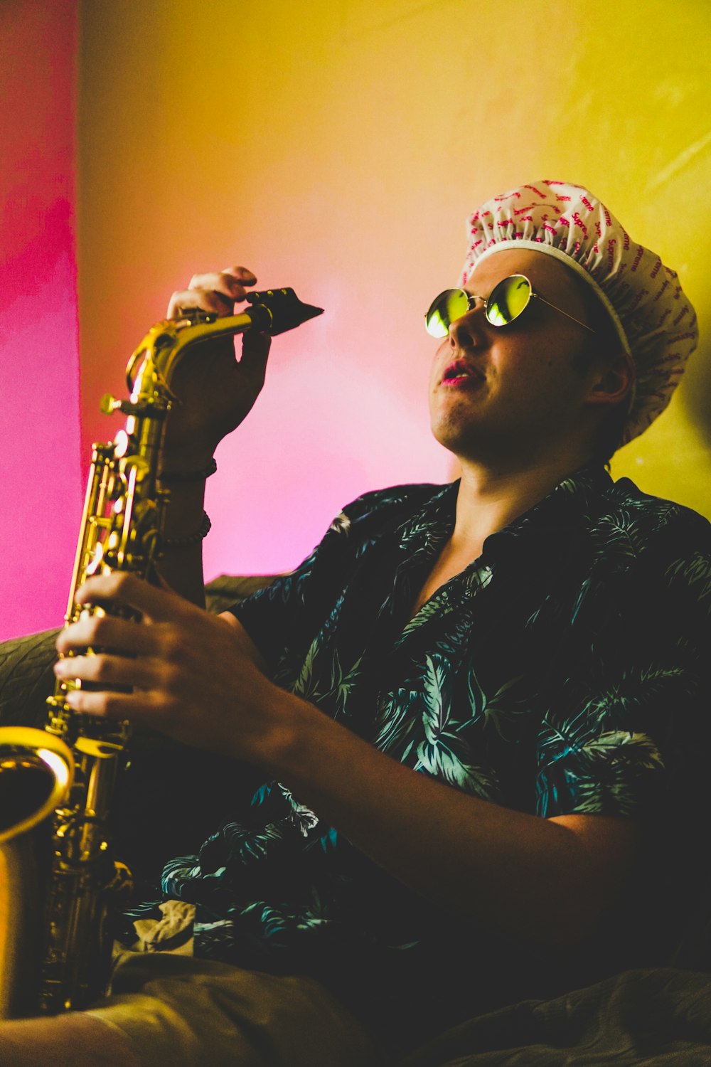 man sitting and holding brass saxophone