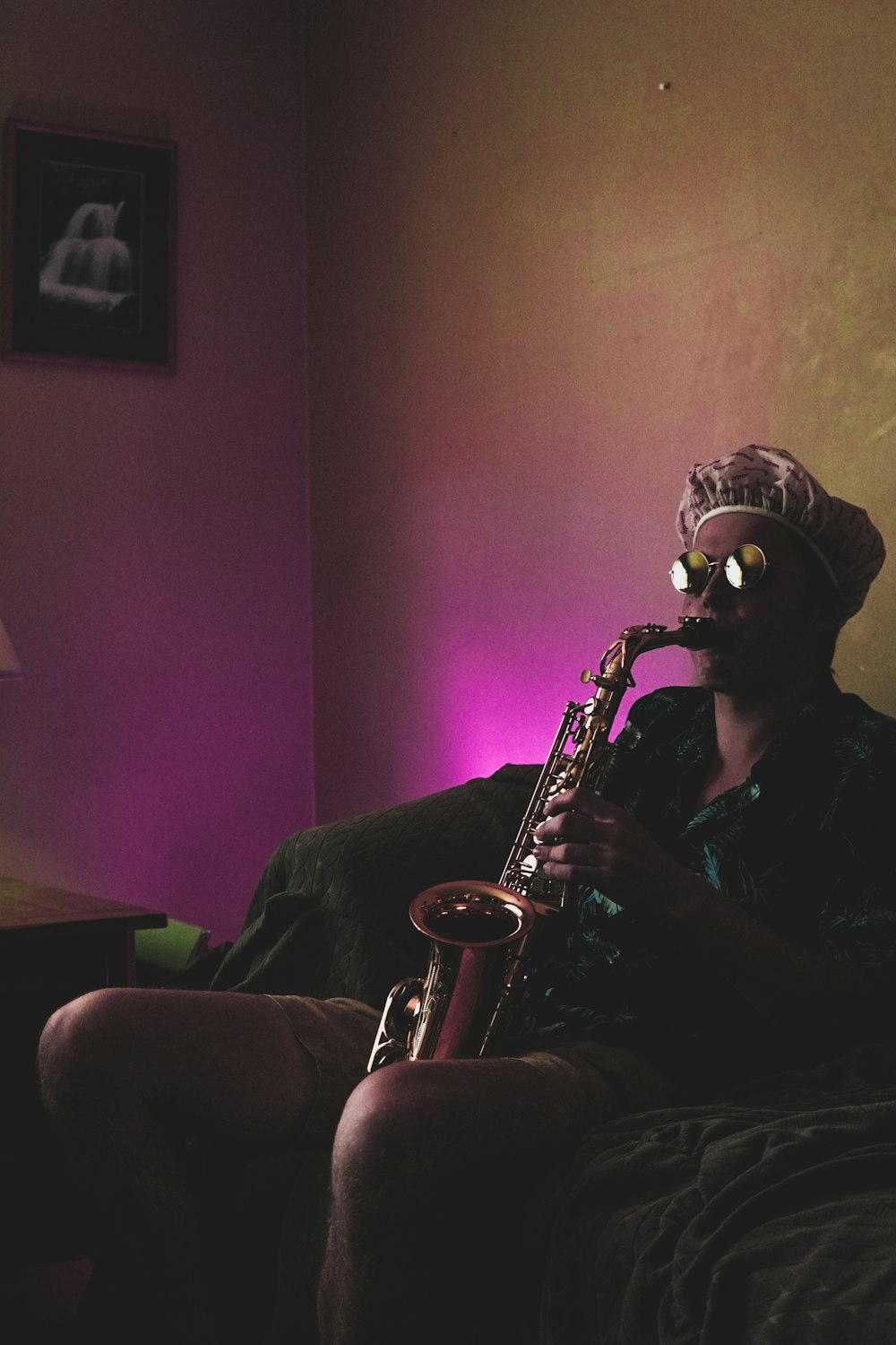 Mann sitzt, während er Blechblassaxophon spielt