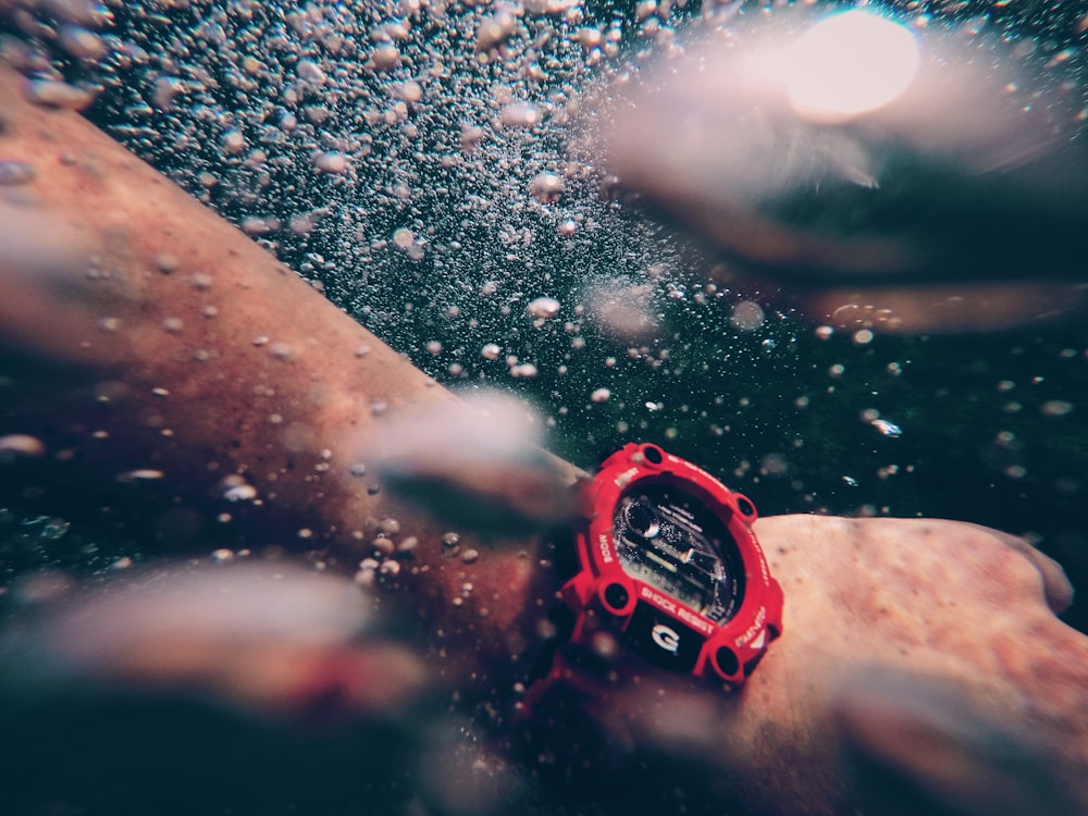 person wearing red and black digital watch