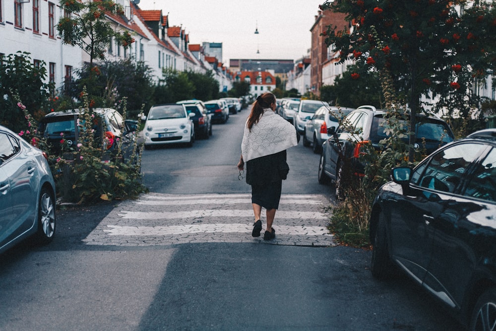 woman walking beside parked vehicles