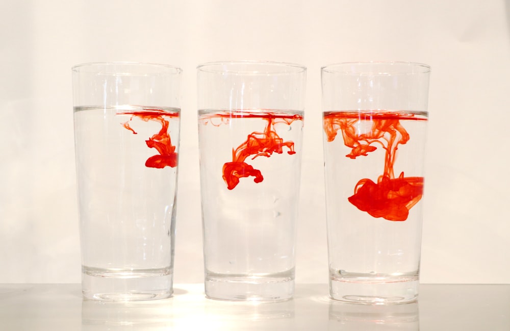 polvo rojo en tres vasos transparentes