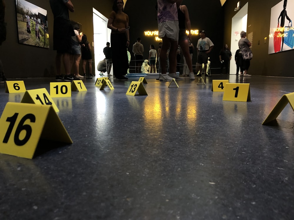 people sitting and standing inside building with numbers on floor