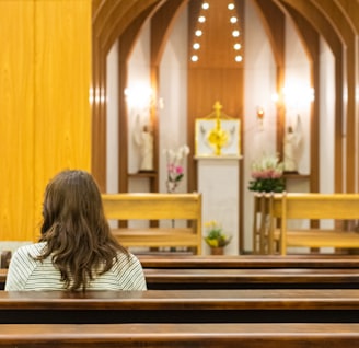 woman sitting on bench inside church