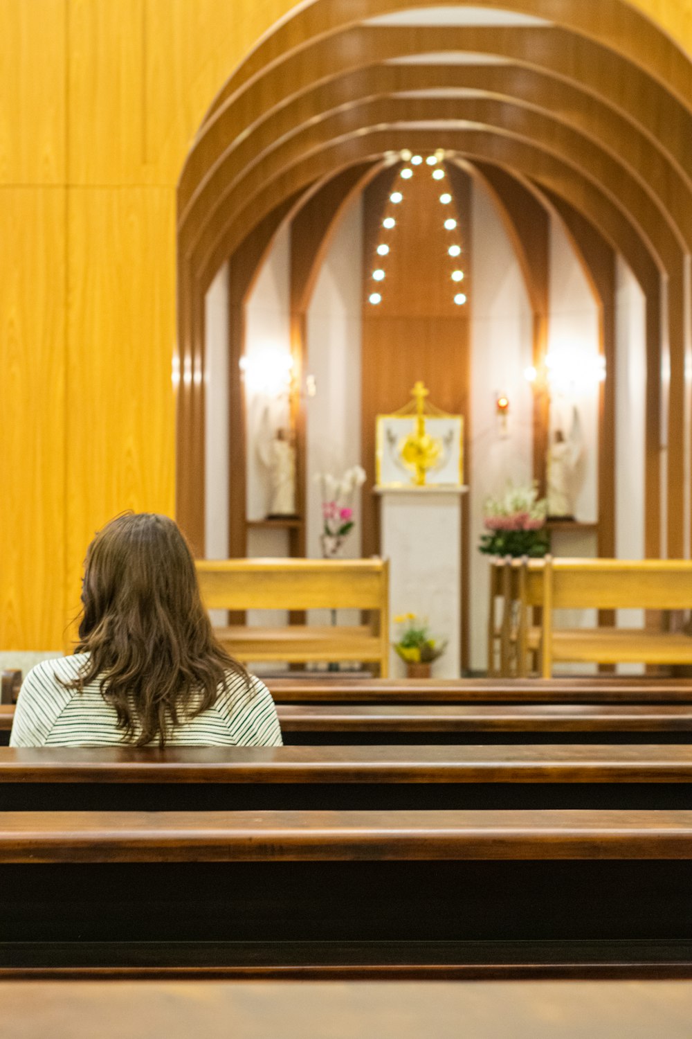 Mujer sentada en un banco dentro de la iglesia