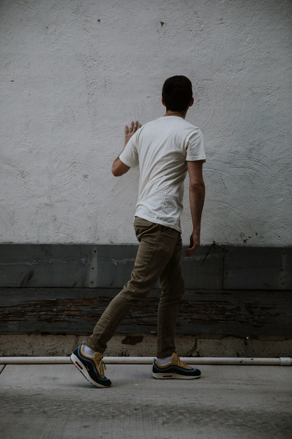 man holding white wall