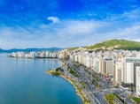 city with high-rise buildings viewing blue sea under blue and white skies