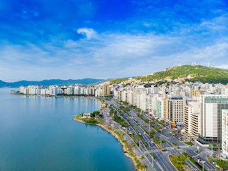 city with high-rise buildings viewing blue sea under blue and white skies