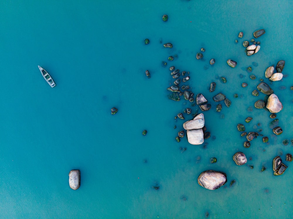 Photographie aérienne d’un bateau flottant près des rochers