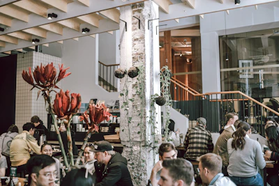 A bustling urban cafe with people chatting over steaming mugs.