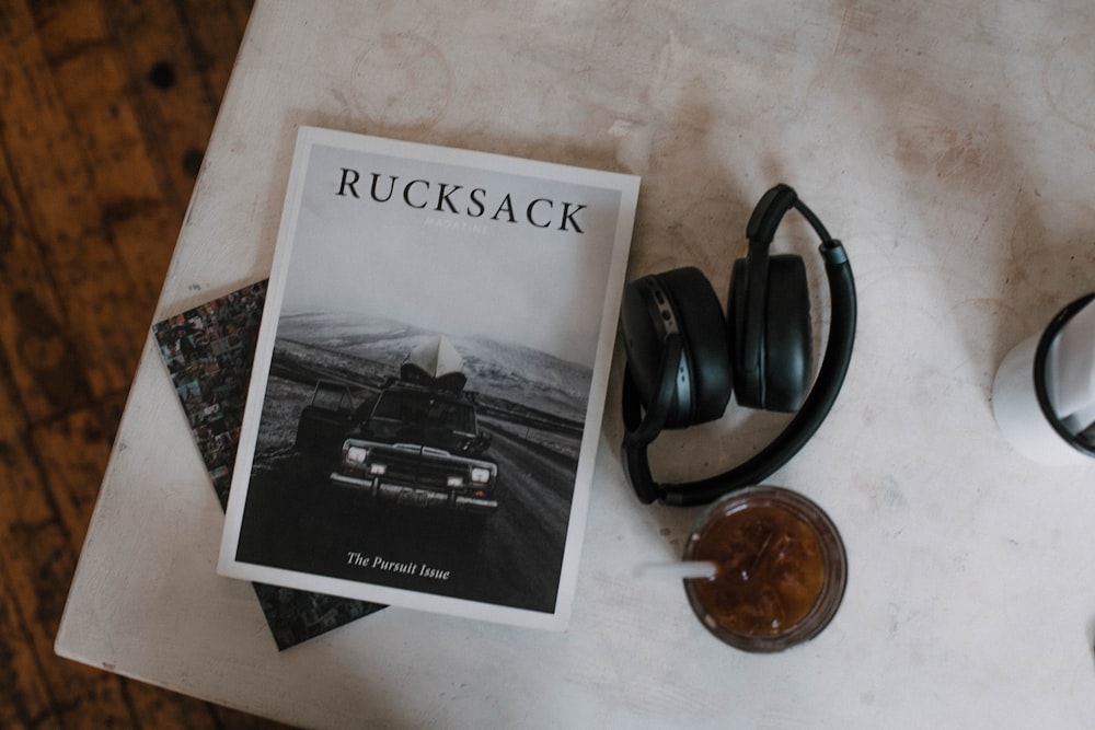 Rucksack book beside black folding headphones