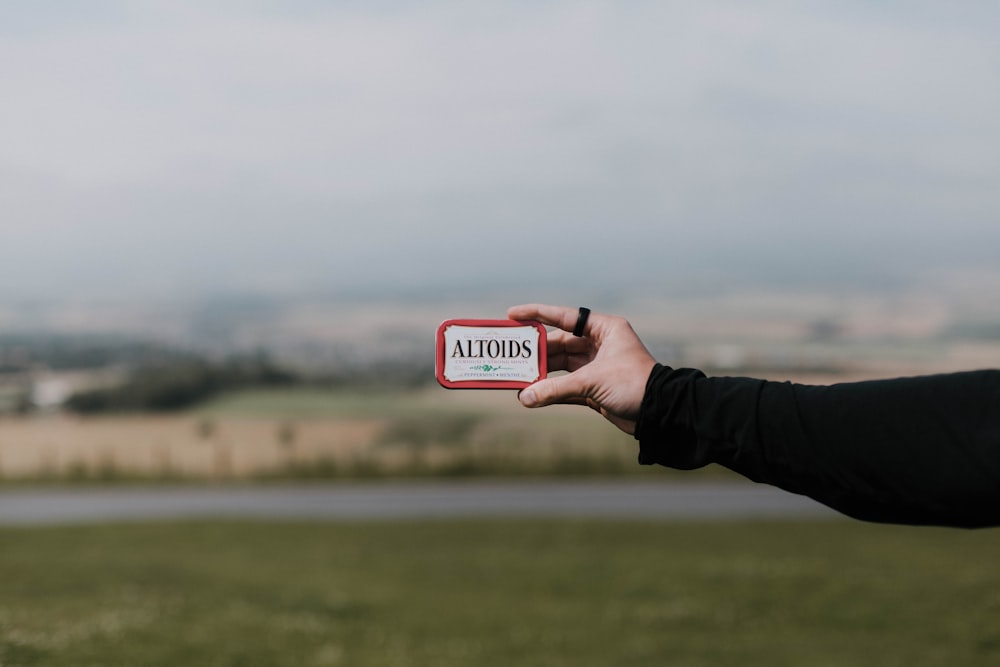 can of Altoids held at grass field