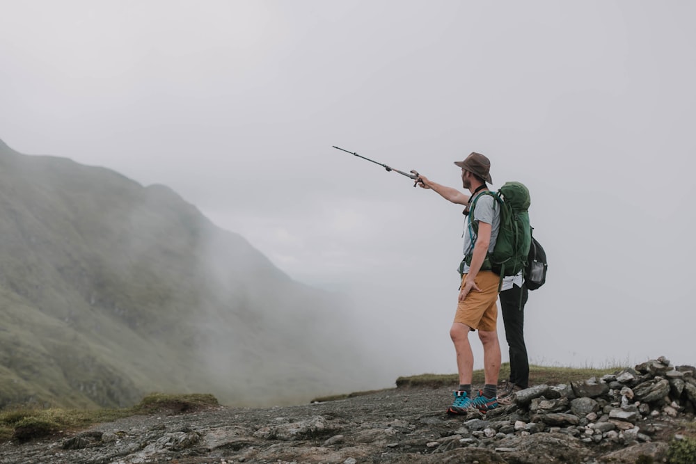 man and woman standing on top of foggy hill