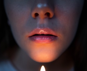 Close-up of Freddy’s burned face illuminated by flickering candlelight.