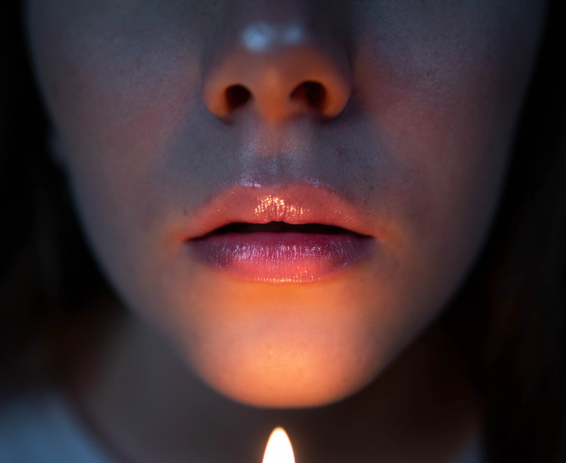 A woman's lips and chin in low, warm light