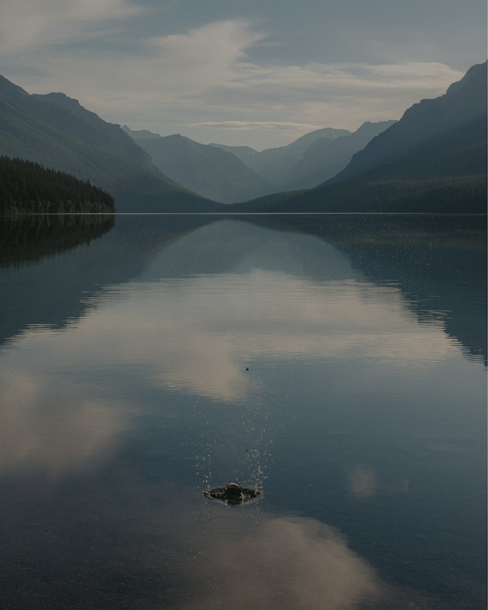 body of water near mountains during daytime