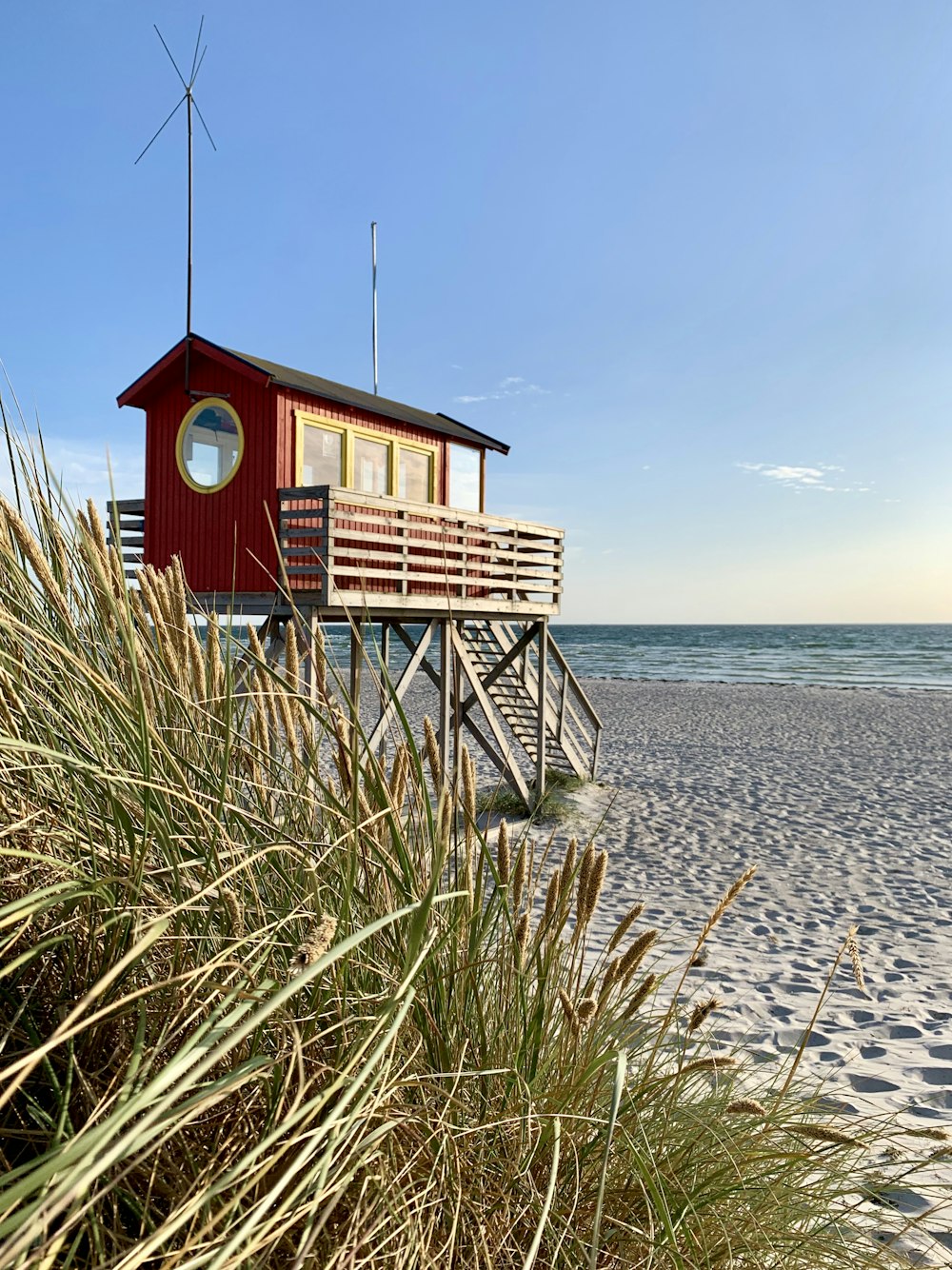 red house near shore during daytime