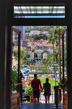 Agent handing over keys to a smiling couple outside a sleek urban apartment building.