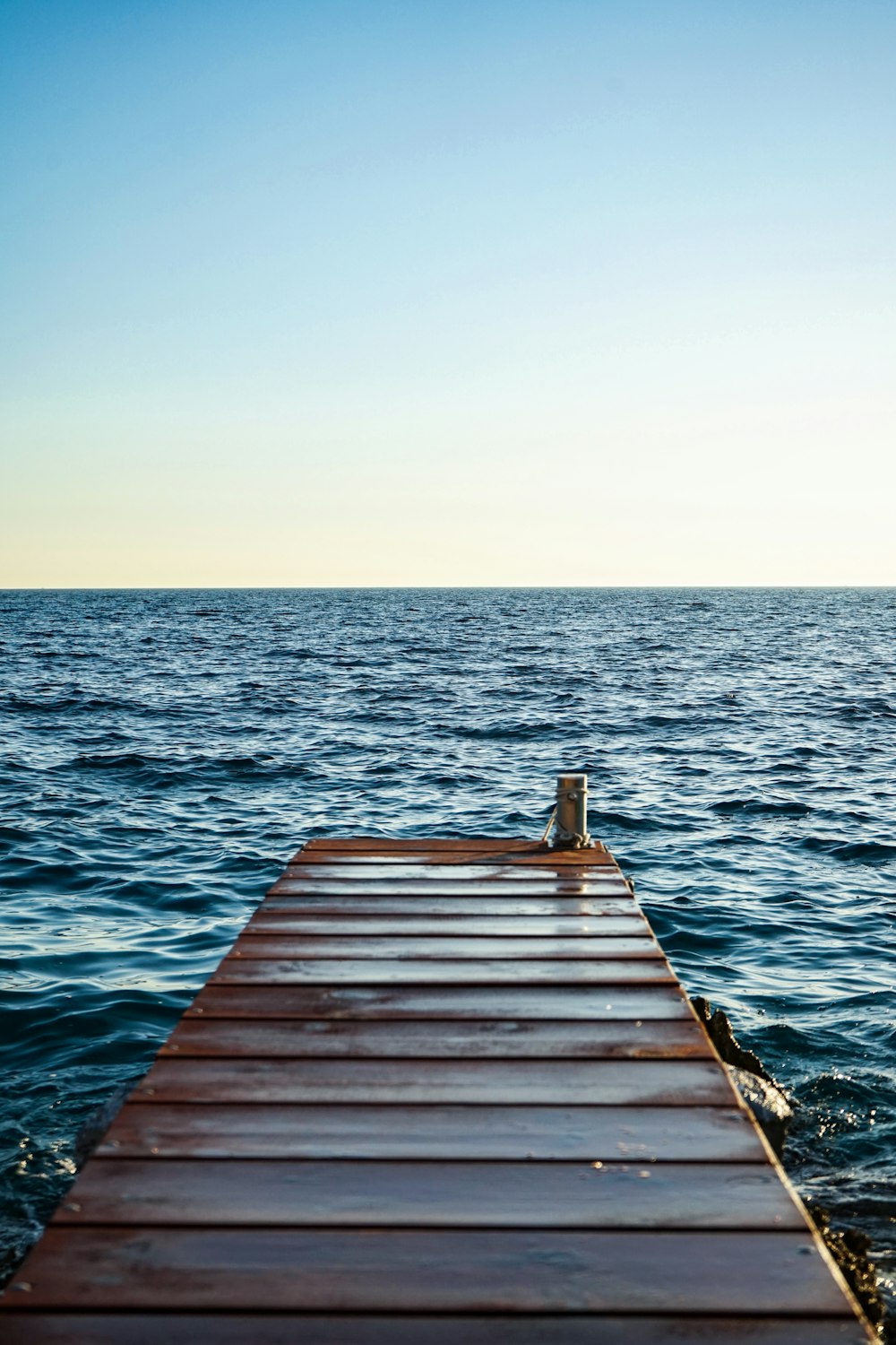 brown wooden dock beside body of water at daytime