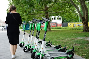 woman walking beside parked electric scooters