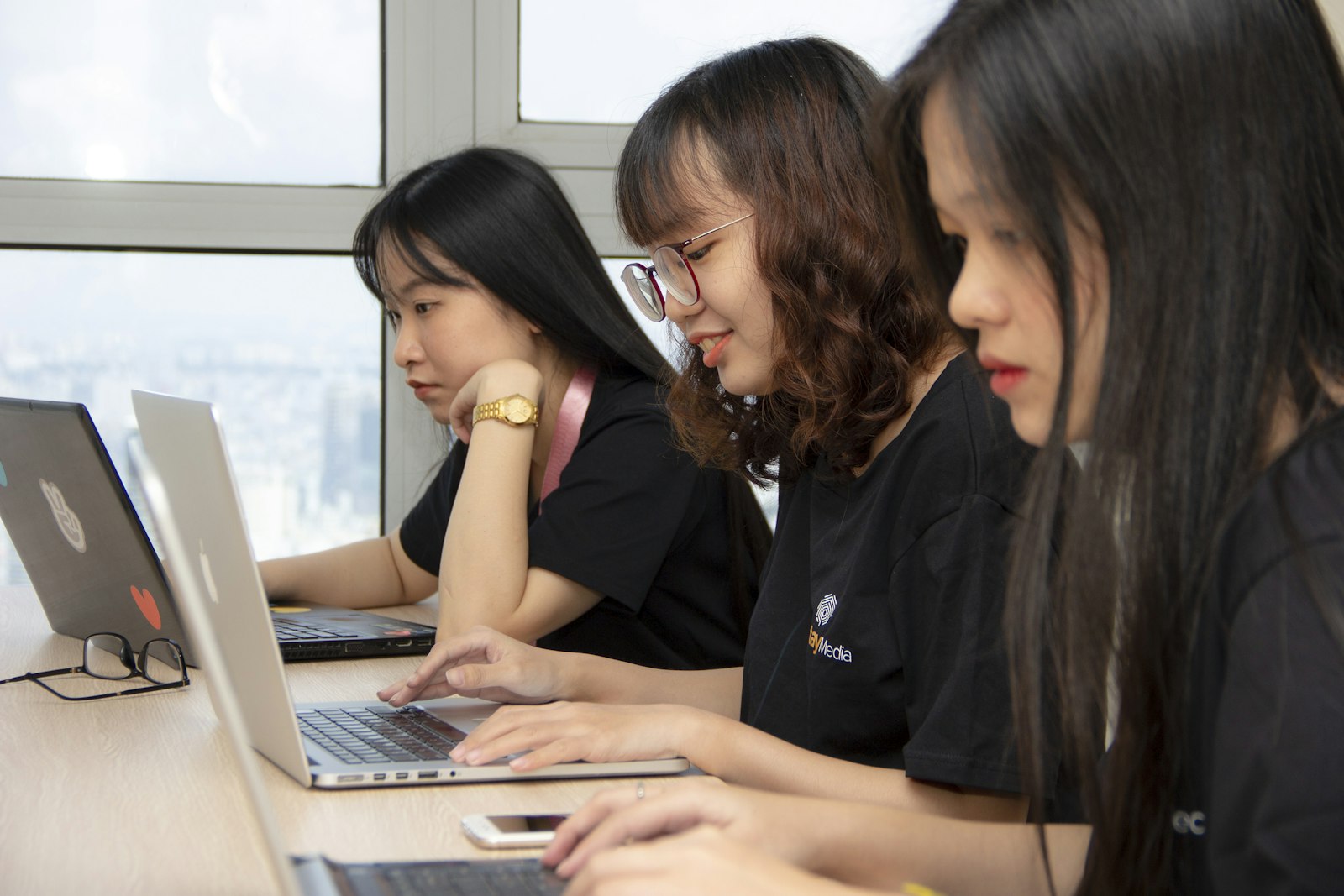 People working together on laptops in a bright room