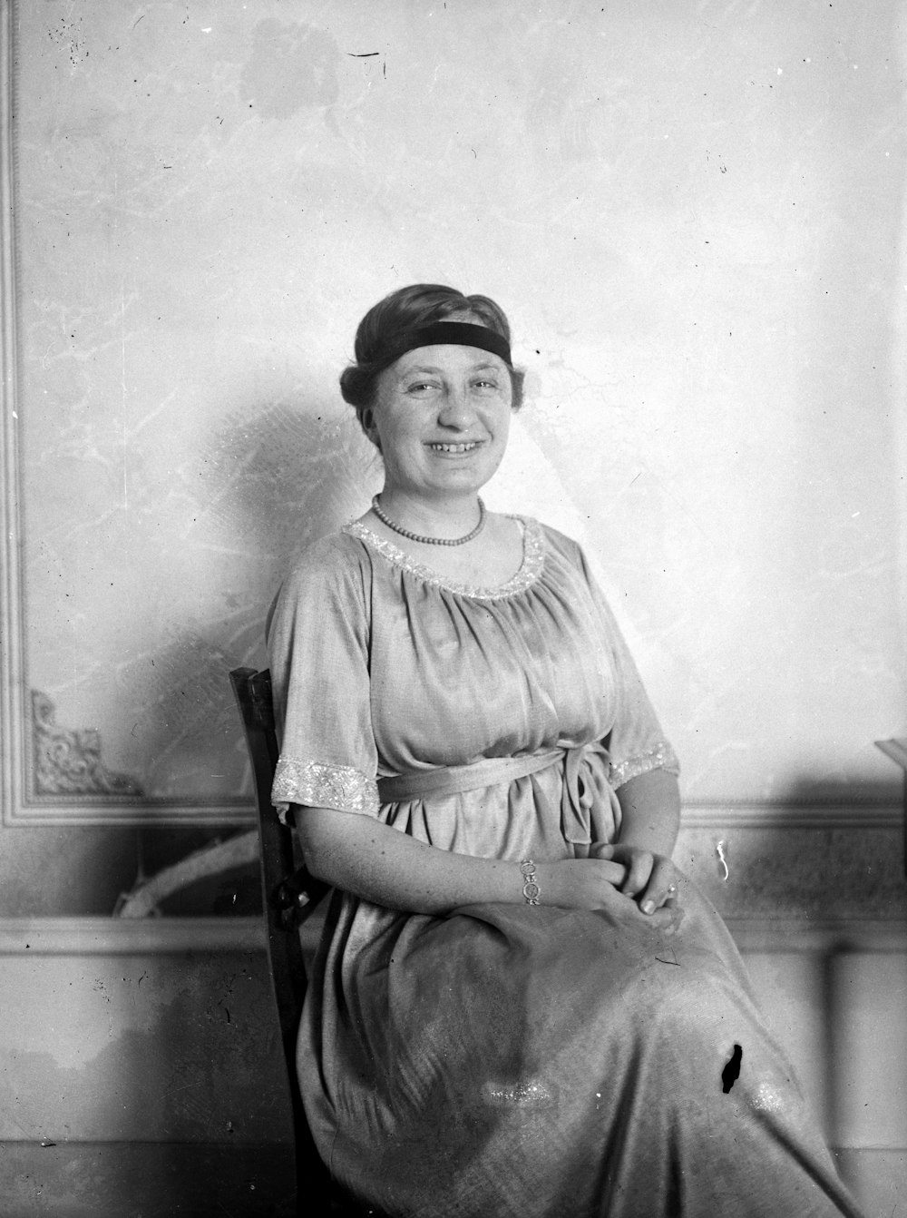 greyscale photo of woman sitting on chair inside room