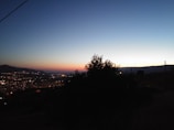 A serene landscape at dusk with glowing city lights.