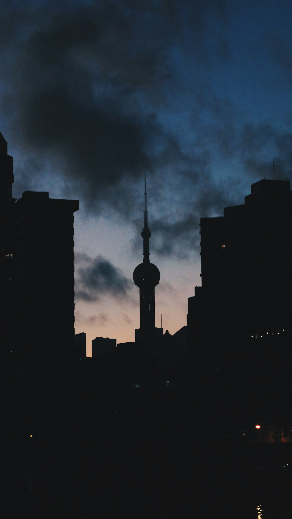 a city skyline at night with a tower in the distance