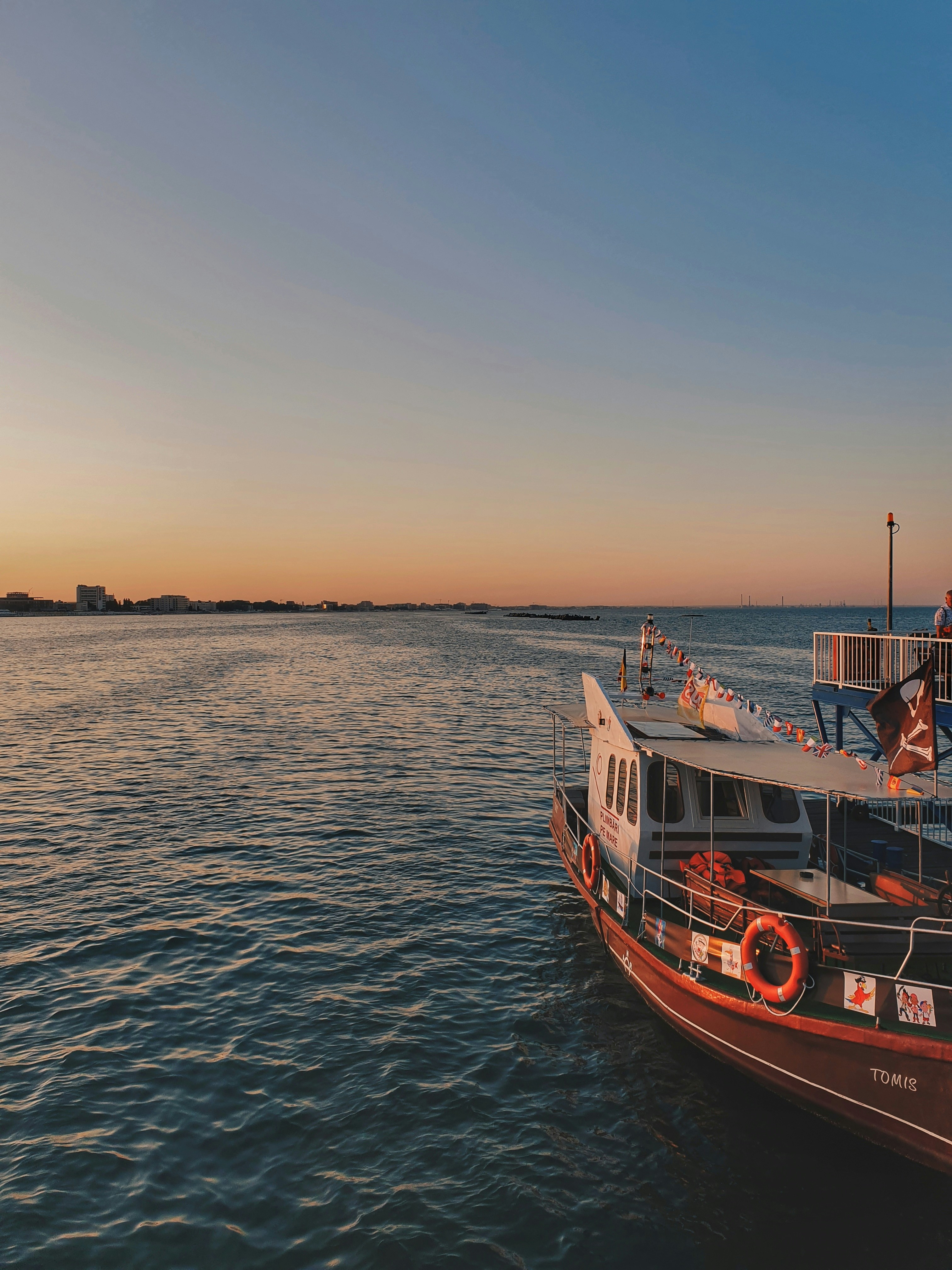 red and white boat on body of water at golden hour