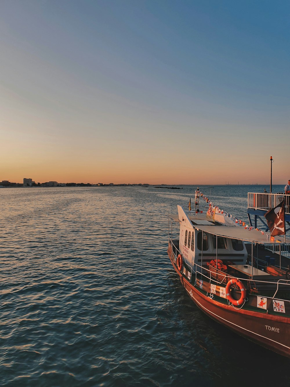 red and white boat on body of water at golden hour