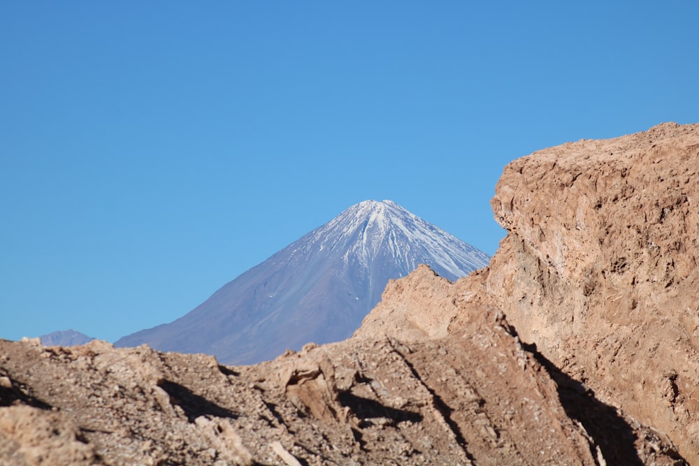 rock formation near mountain under blue sky during daytime
